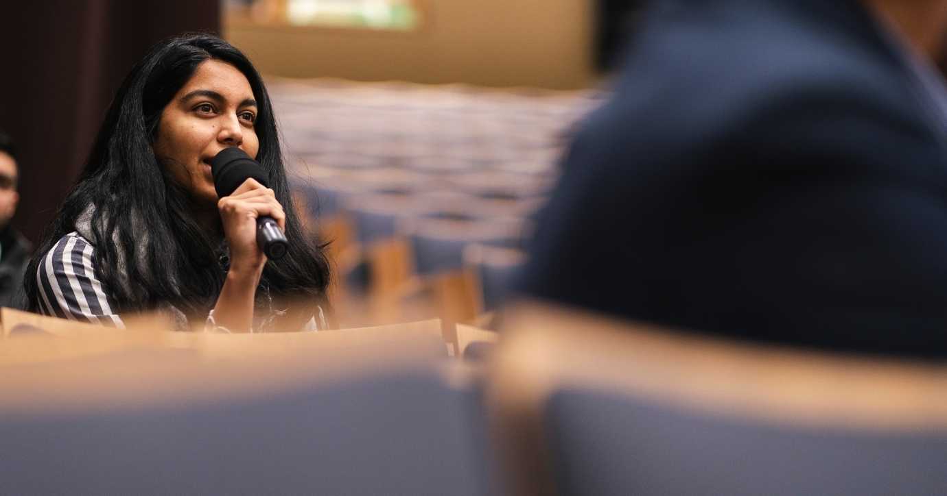 Female student asking question at event with mic