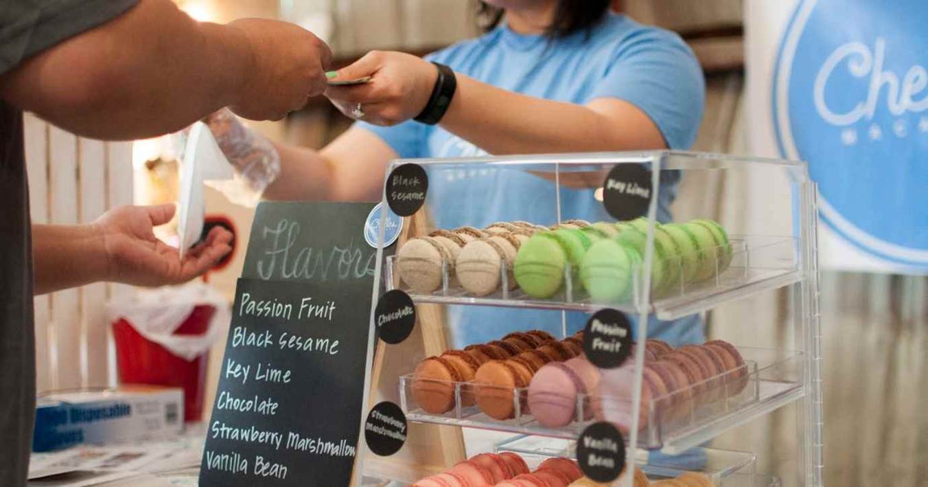 Baker Selling Colourful Macarons To Customer At Vendor Stand