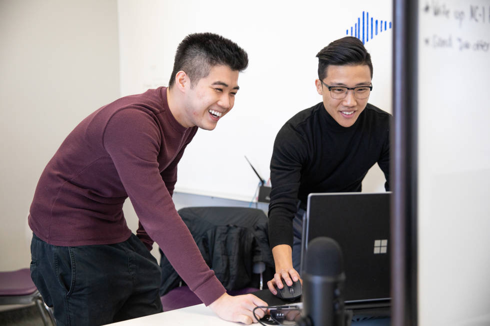 Two accelerator entrepreneurs chatting with each other over a laptop image