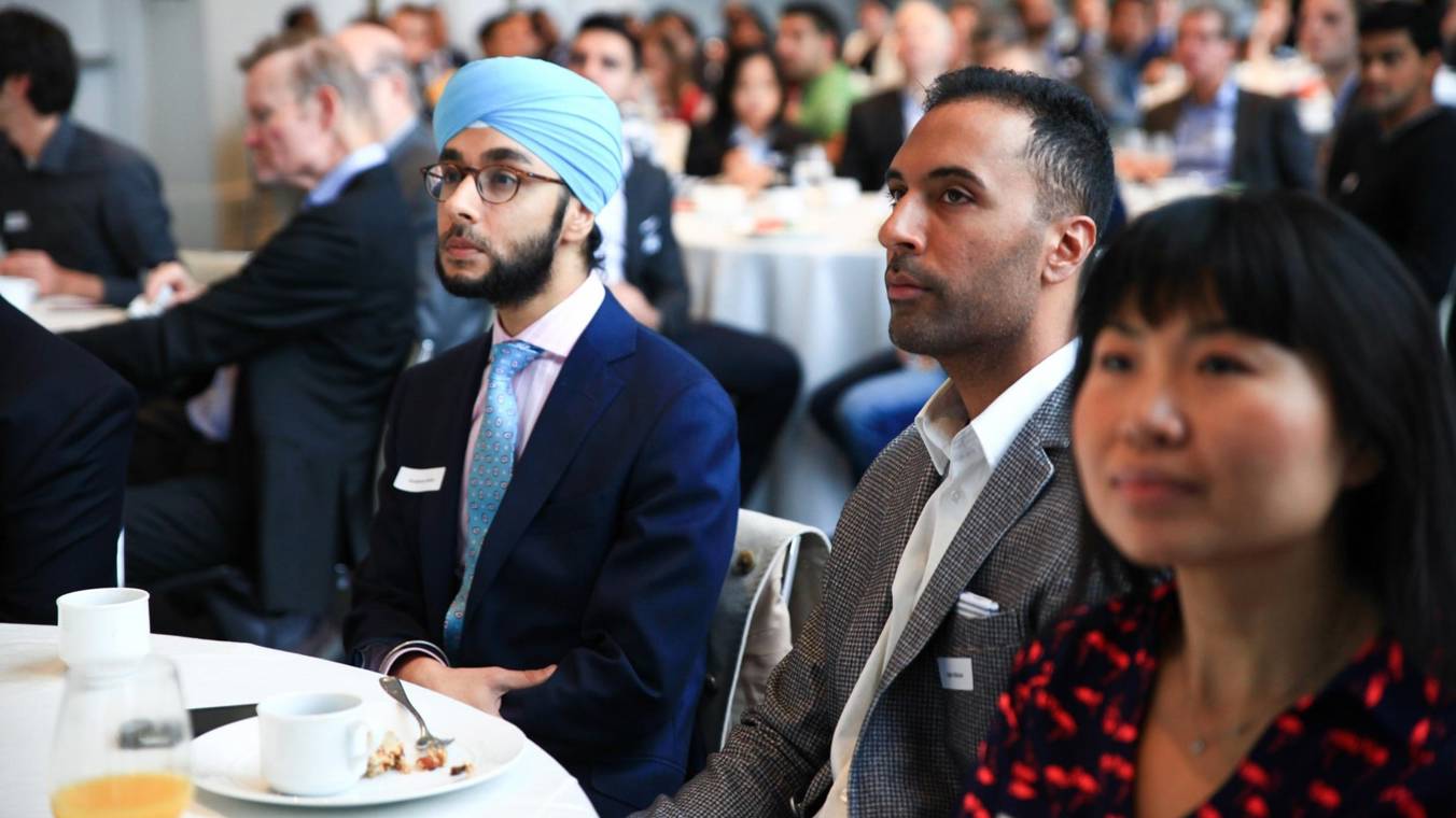 Alumni sitting and listening to a speaker panel