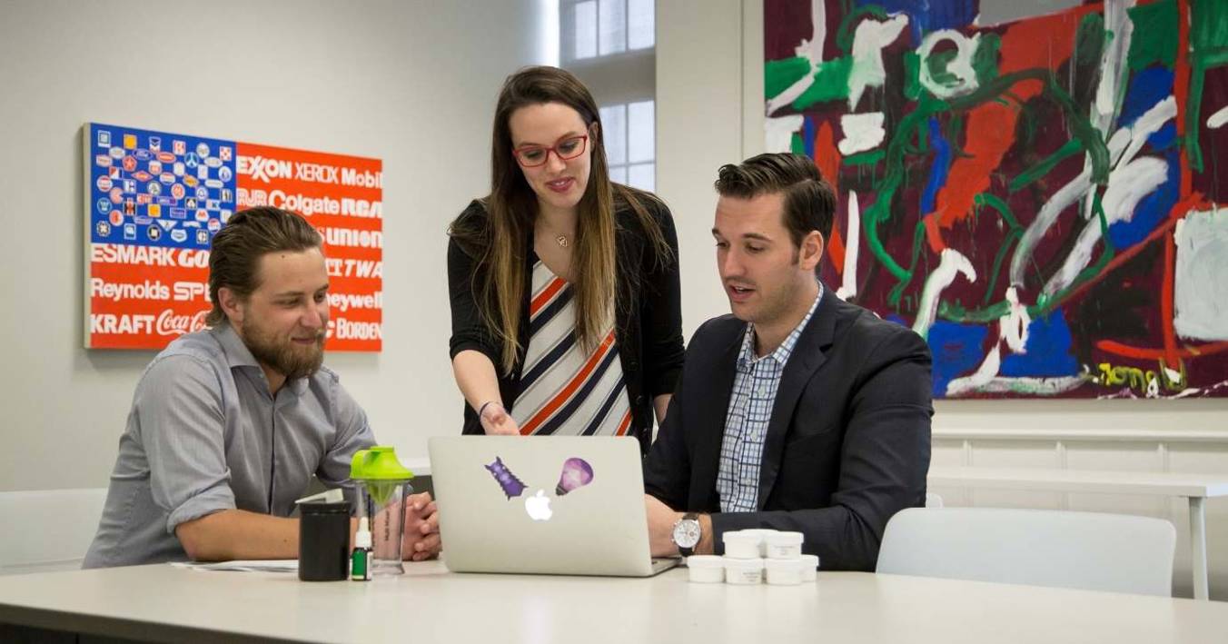 Business Advisor Helping Two MBA Students On A Laptop