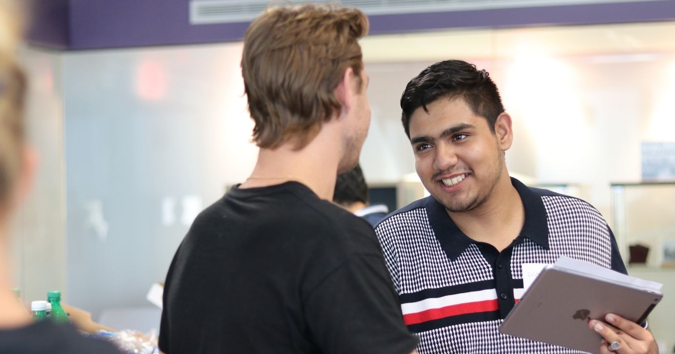 Two student entrepreneurs shaking hands and meeting each other at a networking event