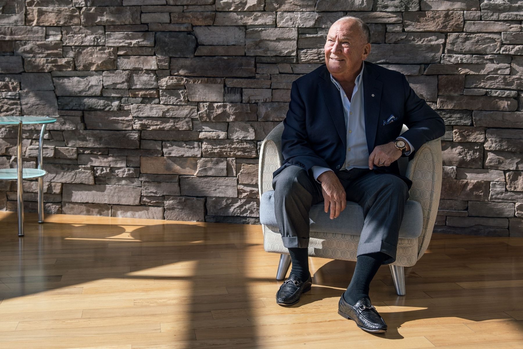 Pierre Morrissette photo sitting in chair with brick backdrop