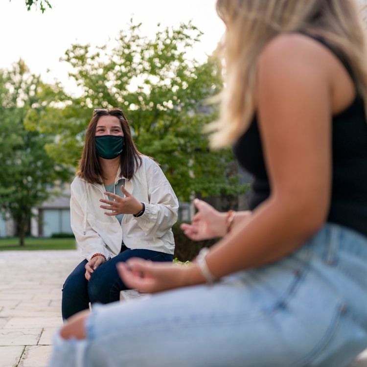 Female Students Chatting With Each Other Outside With Masks On