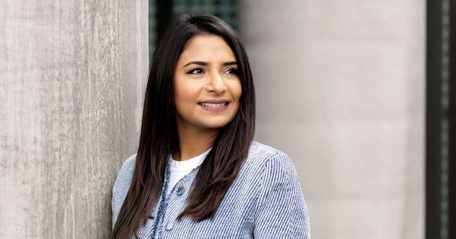 Female Alum Swati Matta Leaning Against Concrete Wall Outside