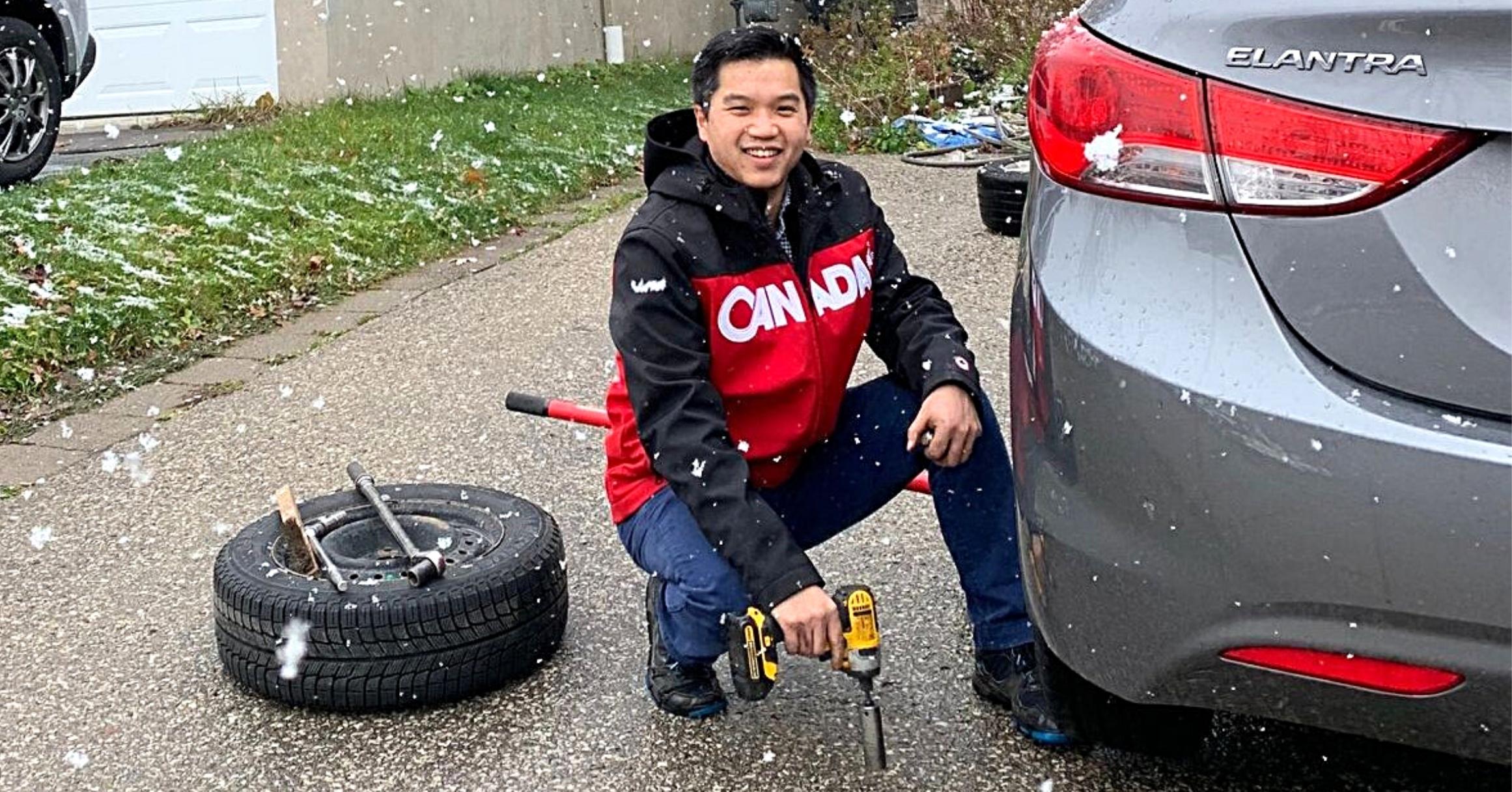 Dennis Ho Founder Of Wheel Easy Changing A Tire In A Driveway